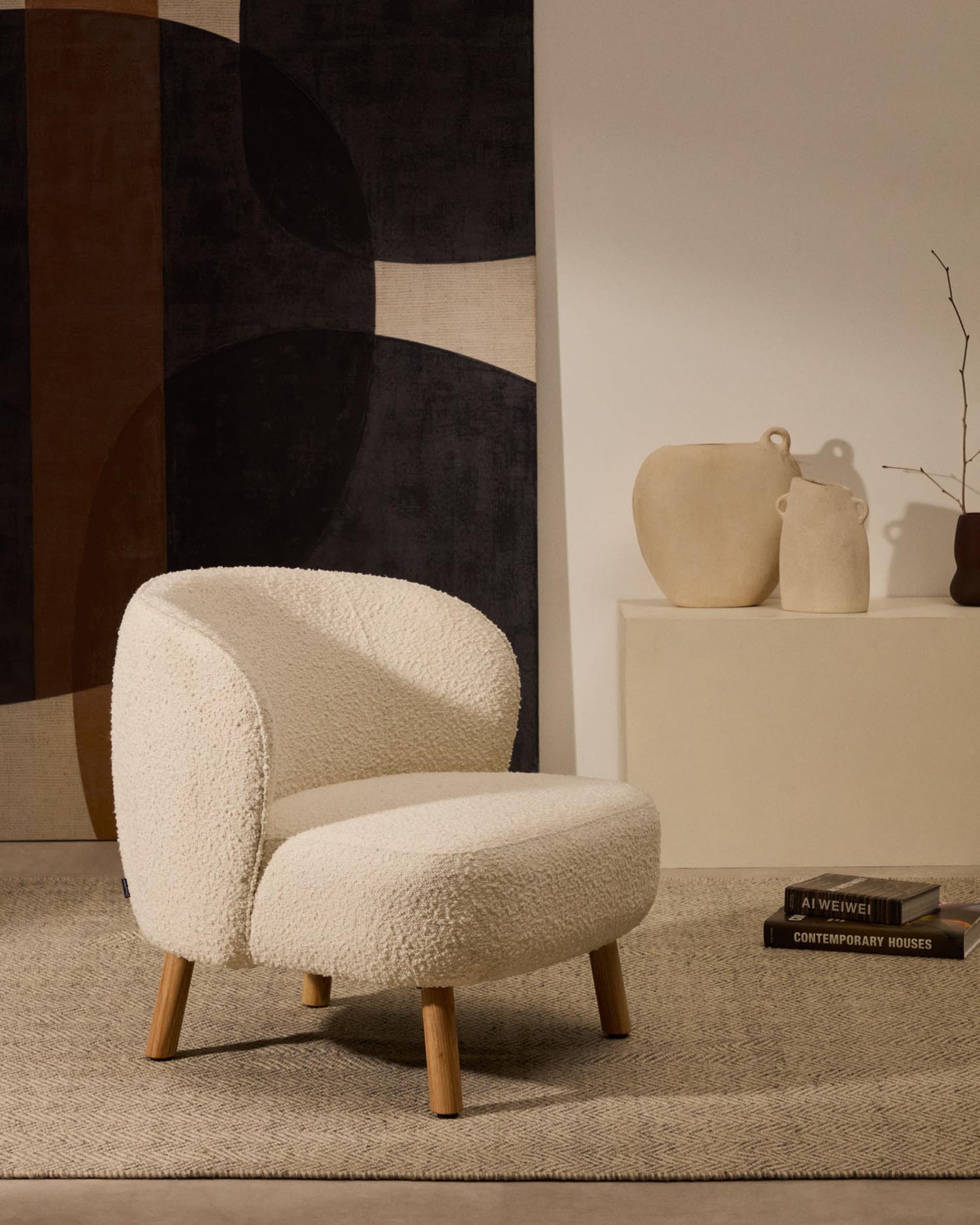 Eleganter Sessel Ulit mit weichem Schaffellbezug und stabilen Beinen aus massivem Buchenholz in natürlichem Finish.