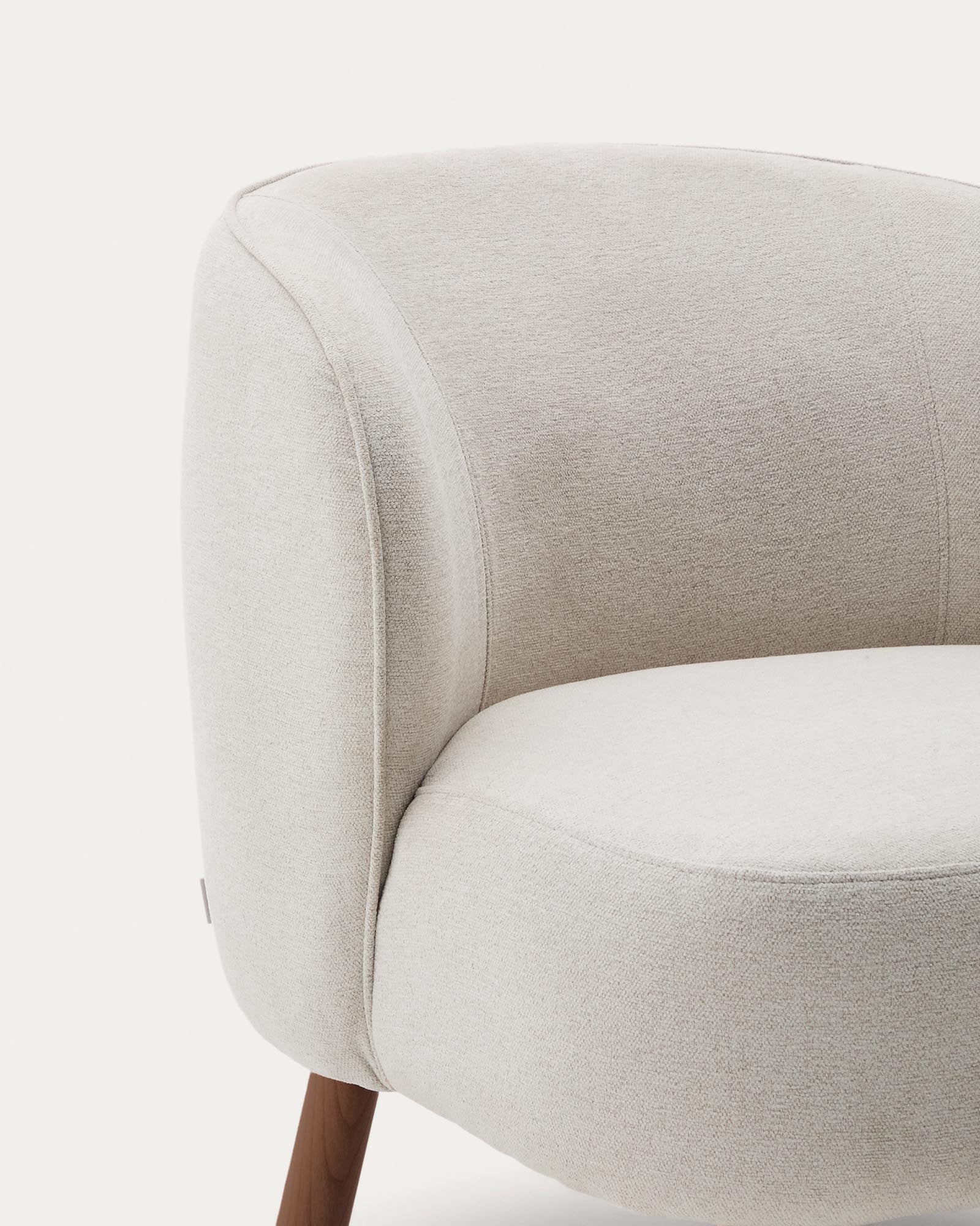Beiger Chenille-Sessel Ulit mit robusten Eschenholzbeinen in edlem Nussbaum-Finish, perfekt für moderne und gemütliche Wohnambiente.