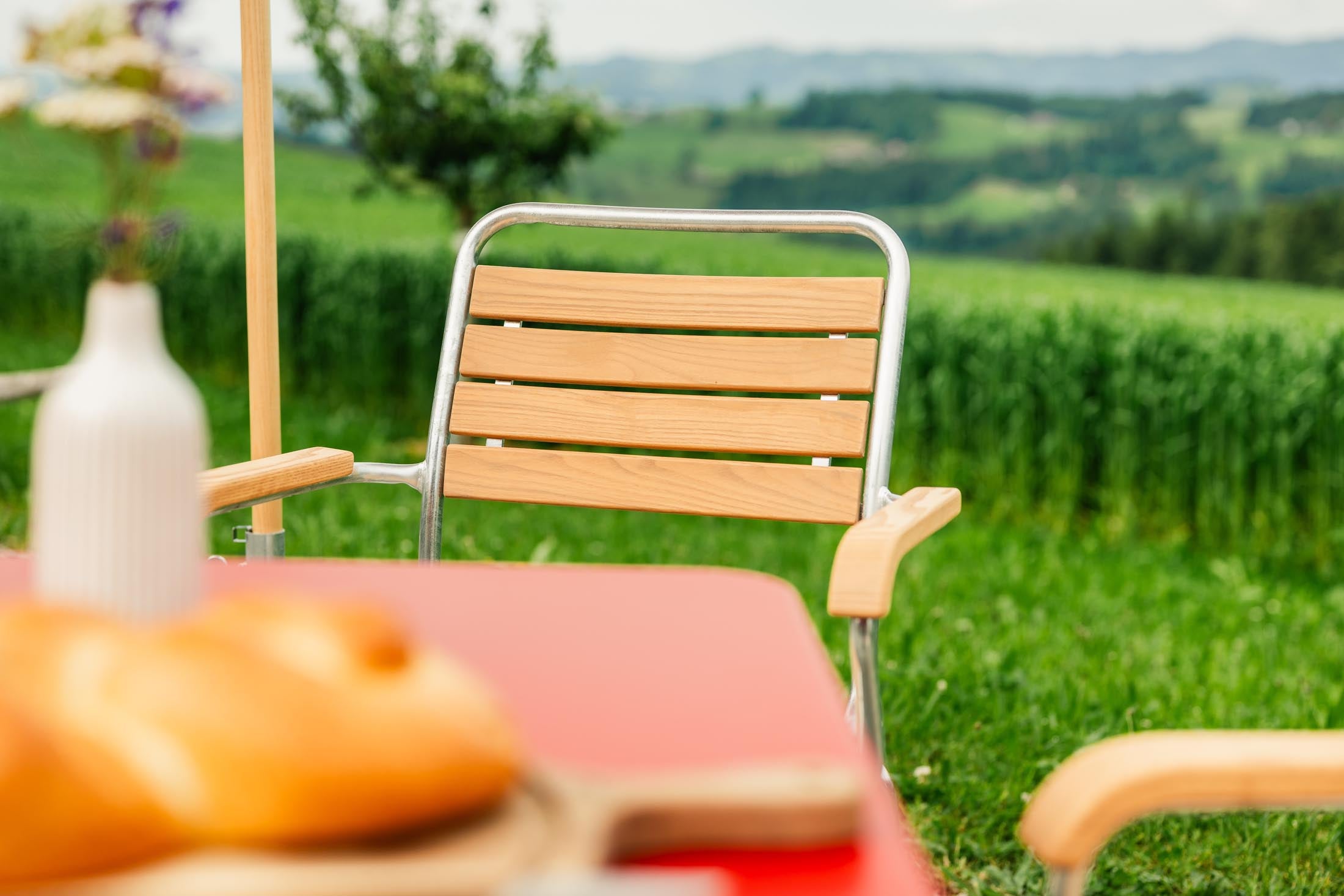 Rigi Holzlatten-Gartenstuhl mit Armlehne in Natur geölt präsentiert im Onlineshop von KAQTU Design AG. Gartenstuhl mit Armlehnen ist von Schaffner