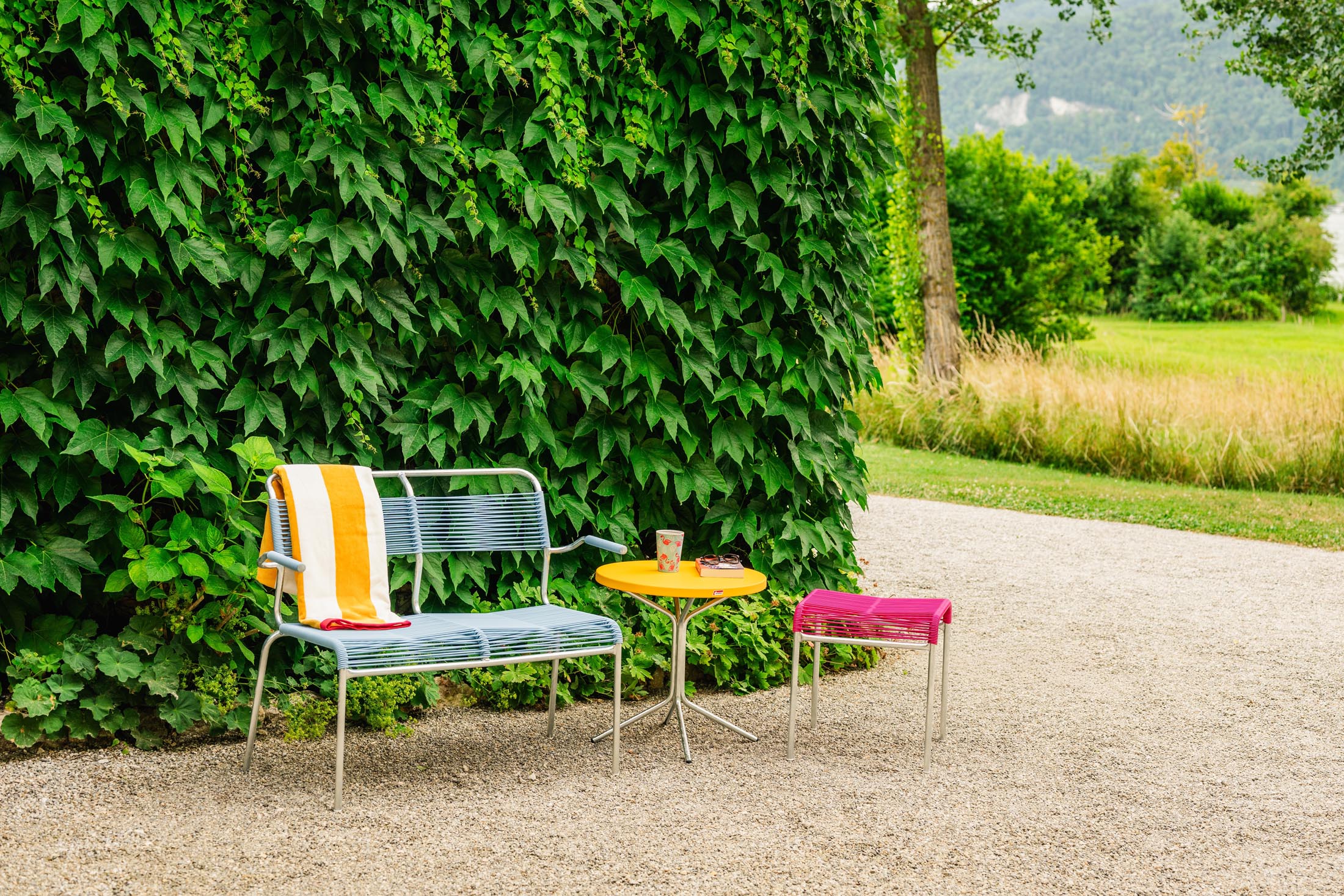 Säntis Spaghetti-2er Gartenbank mit Armlehne in Pastellblau präsentiert im Onlineshop von KAQTU Design AG. Gartenbank ist von Schaffner