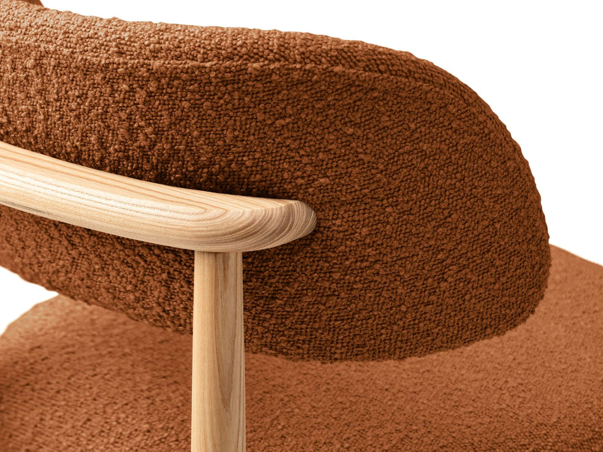 Zwei Boucle-Stühle Evan in Beige mit Buchenholz-Beinen, strukturiertem Bouclé-Bezug und gepolsterter Sitzfläche vor neutralem Hintergrund.