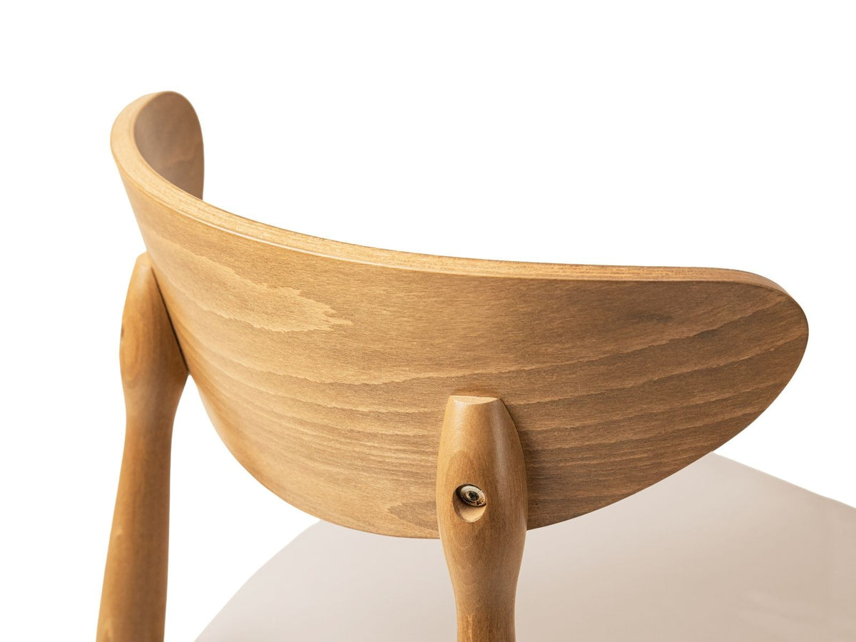 Zwei Leon Stühle mit Samtbezug in Almond Beige, Buchenholz-Beinen und gepolsterter Rückenlehne, Frontalansicht auf hellem Hintergrund.