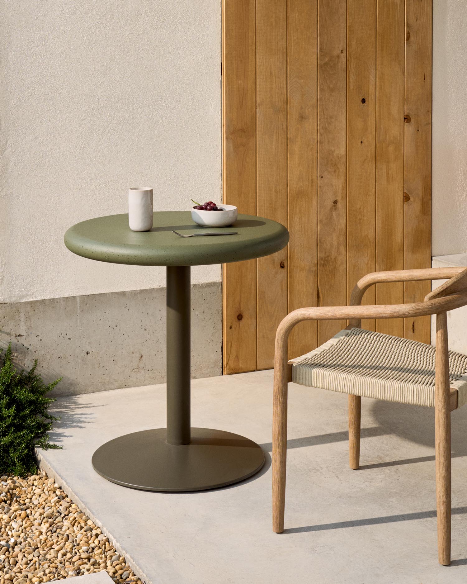 Entdecken Sie den stilvollen runden Outdoor-Tisch Esilda von Kave Home mit einzigartiger Zementplatte und robustem Stahlfuß – ideal für Garten und Terrasse.