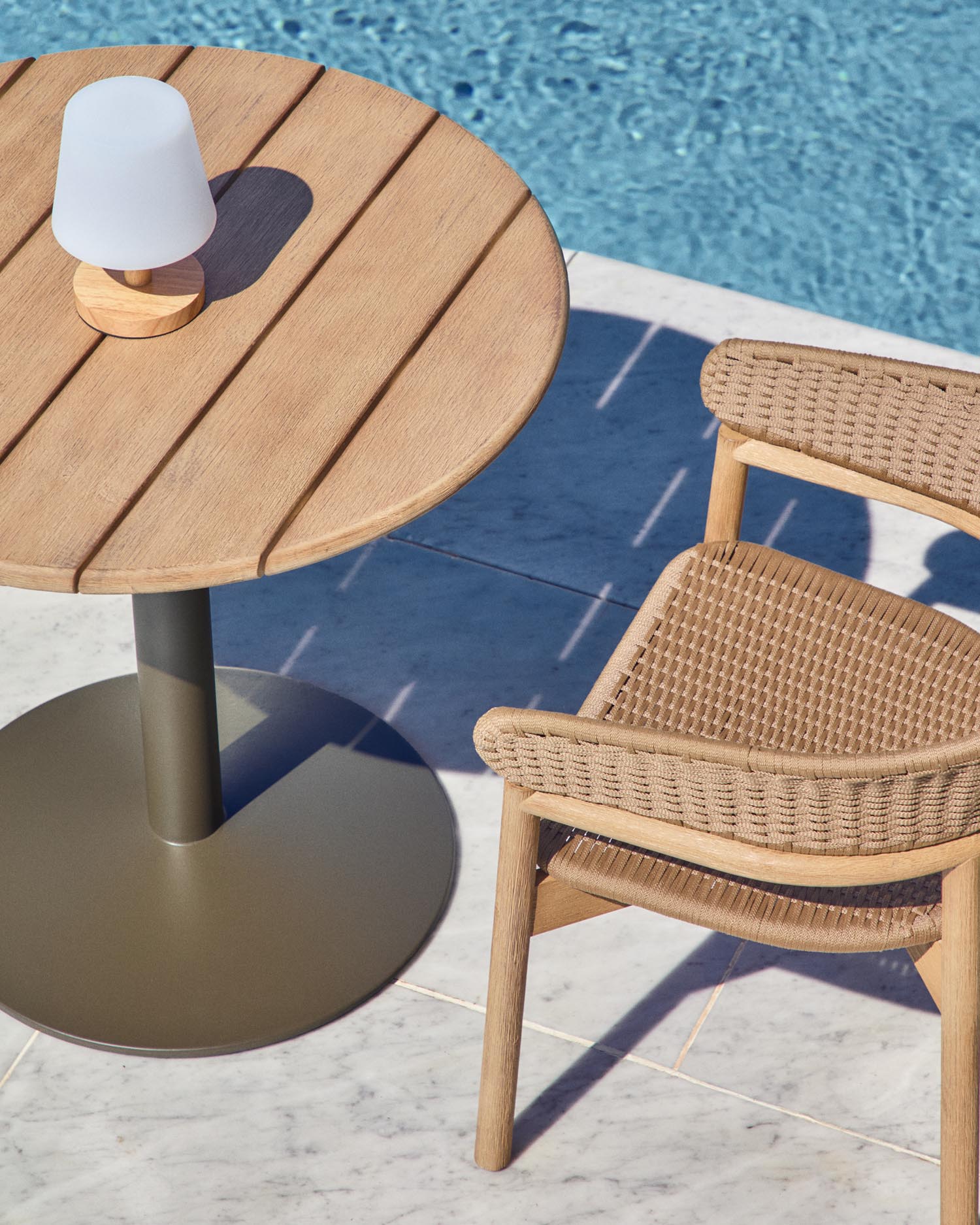 Entdecken Sie den stilvollen runden Outdoor-Tisch Esilda von Kave Home, Ø 80 cm, mit nachhaltiger Akazienholzplatte und grünem Stahlfuß.