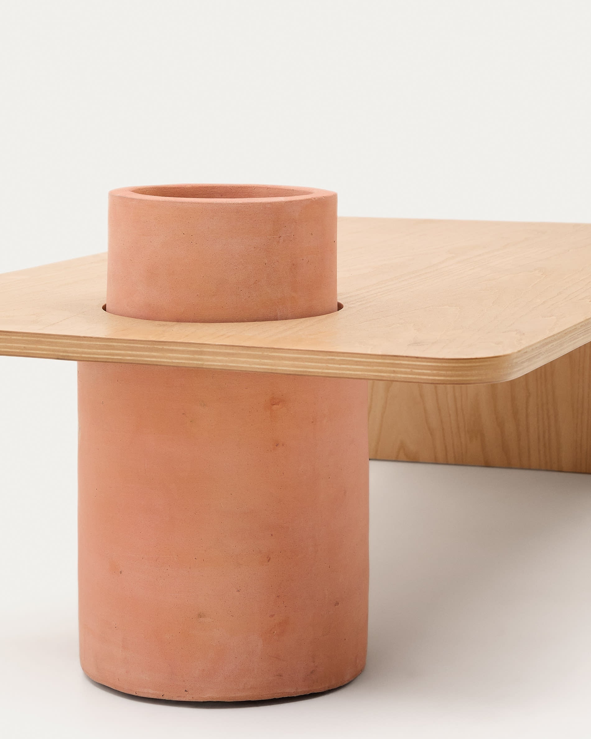 Der Couchtisch Olaria kombiniert edles Eichenfurnier mit einem robusten Terrakotta-Fuß und verleiht Ihrem Raum eine warme, einladende Atmosphäre.