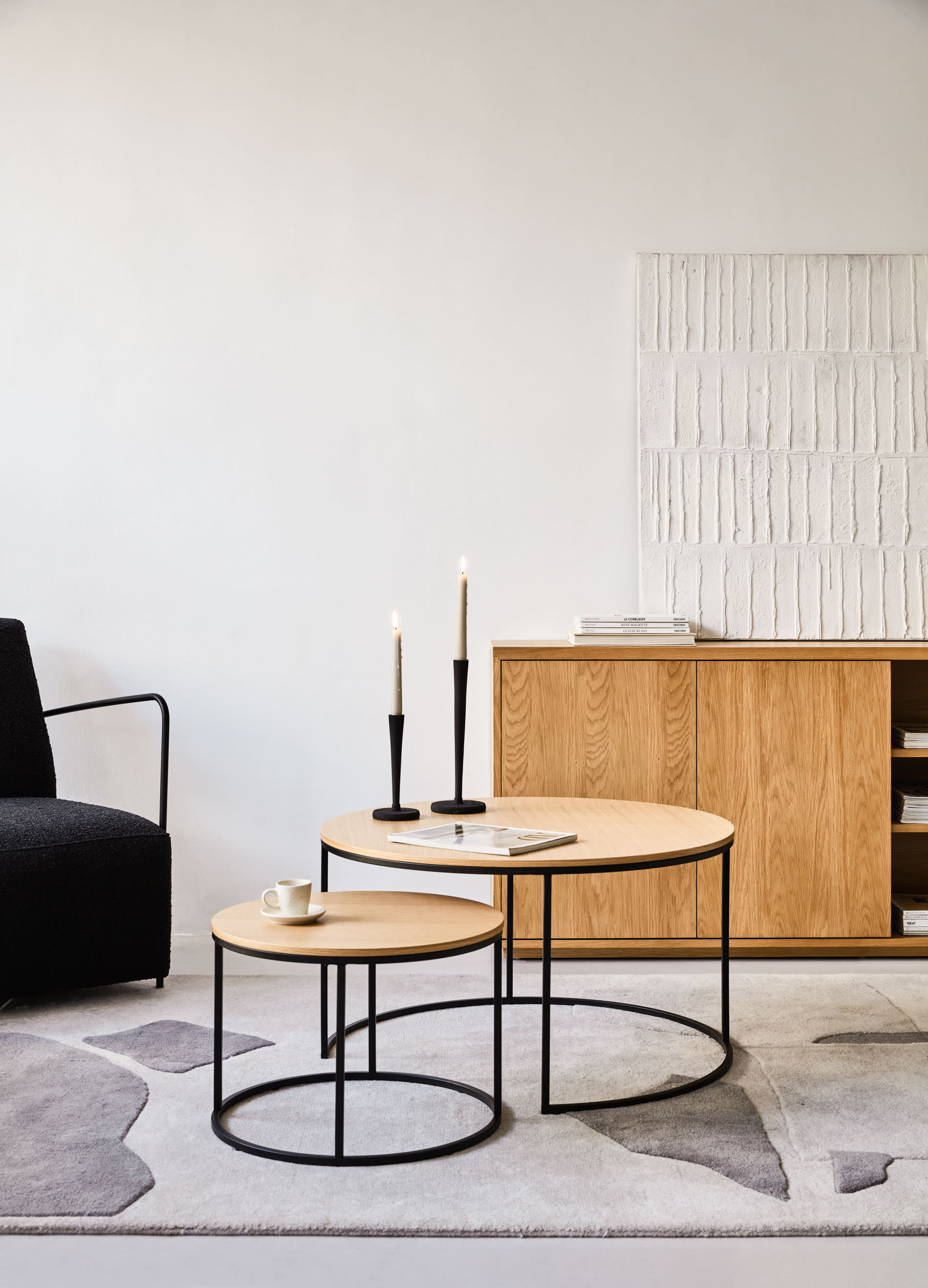 Das Yoana Set umfasst zwei elegante Beistelltische mit Eichenfurnier und schwarzem Metall, perfekt für zeitgemässe Wohnräume.