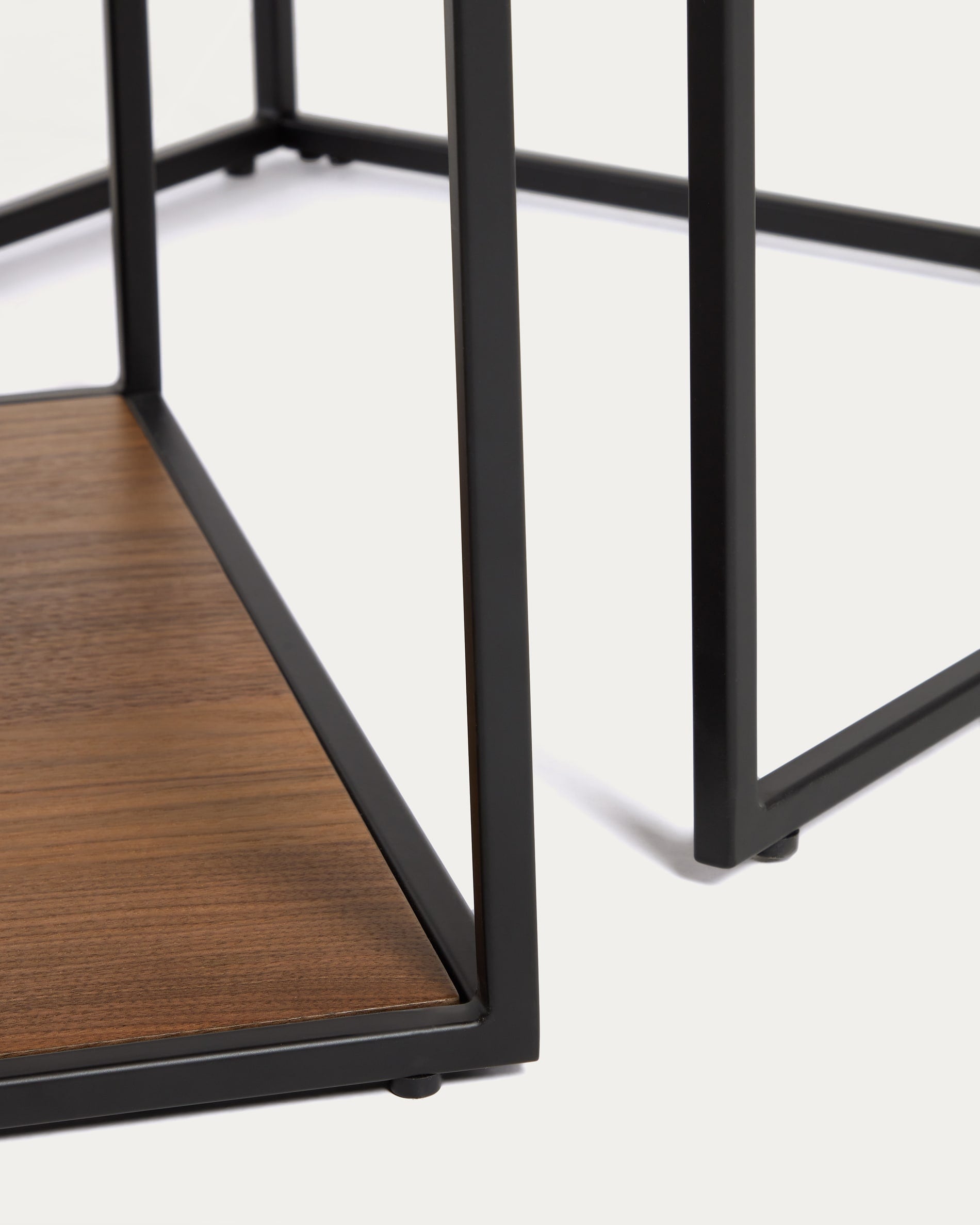 Erleben Sie das Yoana Set: Zwei stilvolle Beistelltische aus warmem Nussholzfurnier und modernem, schwarzem Metallgestell – ideal für jedes Zuhause.