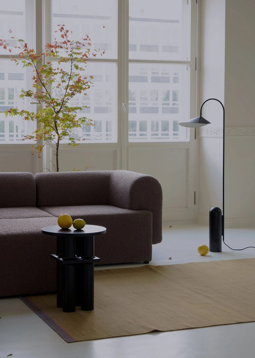Modulares Sofa Tori von Tamo in Anthrazit mit gepolsterter Sitzfläche, abgerundeter Rückenlehne und Kunststofffüssen.