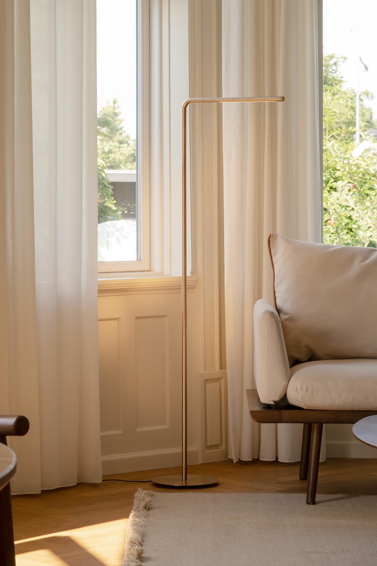 Elegante Omni Floor Stehleuchte in Messing von Umage, ideal für stilvolle Wohnräume und stimmungsvolle Beleuchtung.