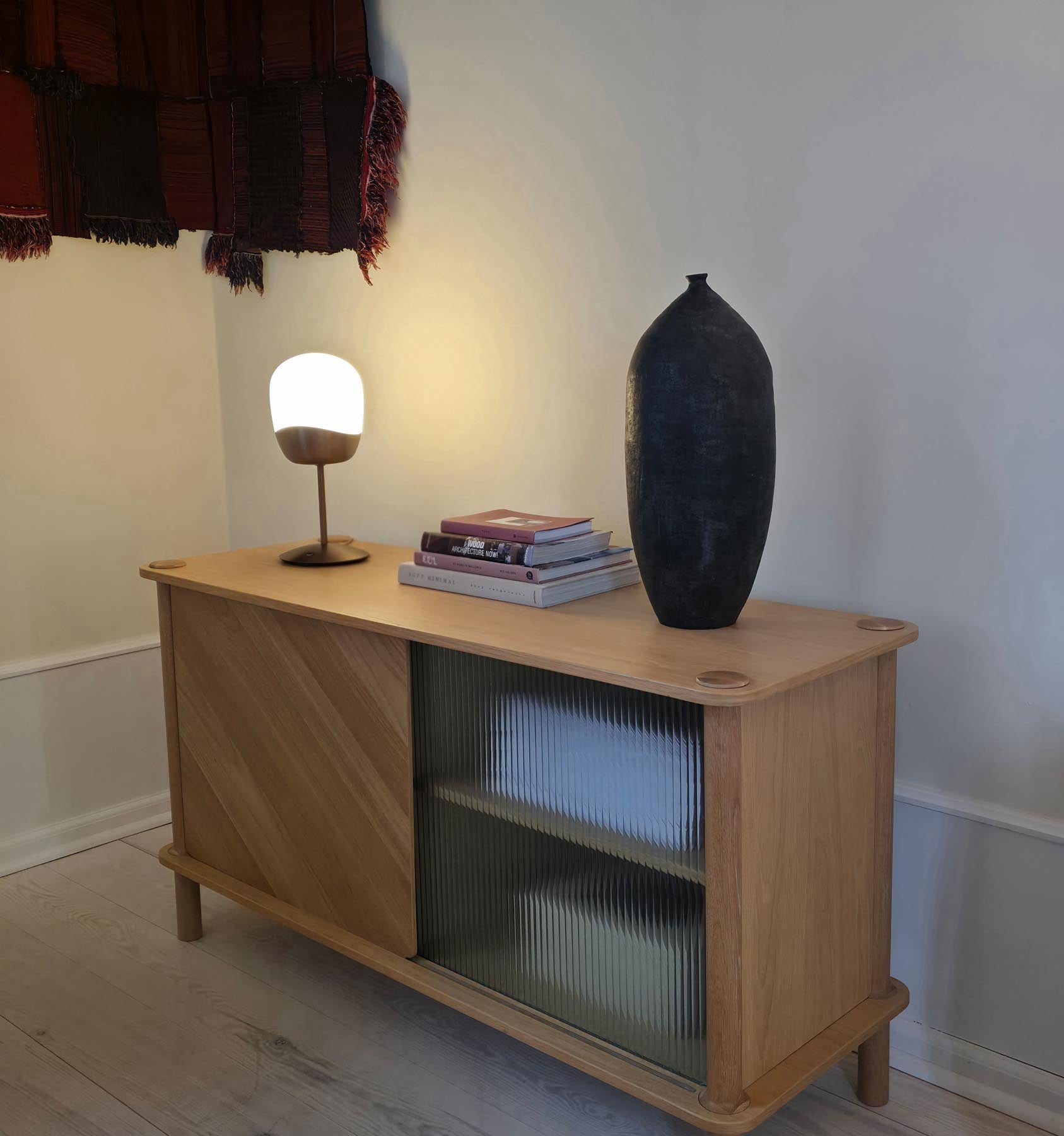 Moderne Spring Tischlampe von Umage, die mit ihrem minimalistischen Stil und warmem Licht eine gemütliche Atmosphäre schafft.