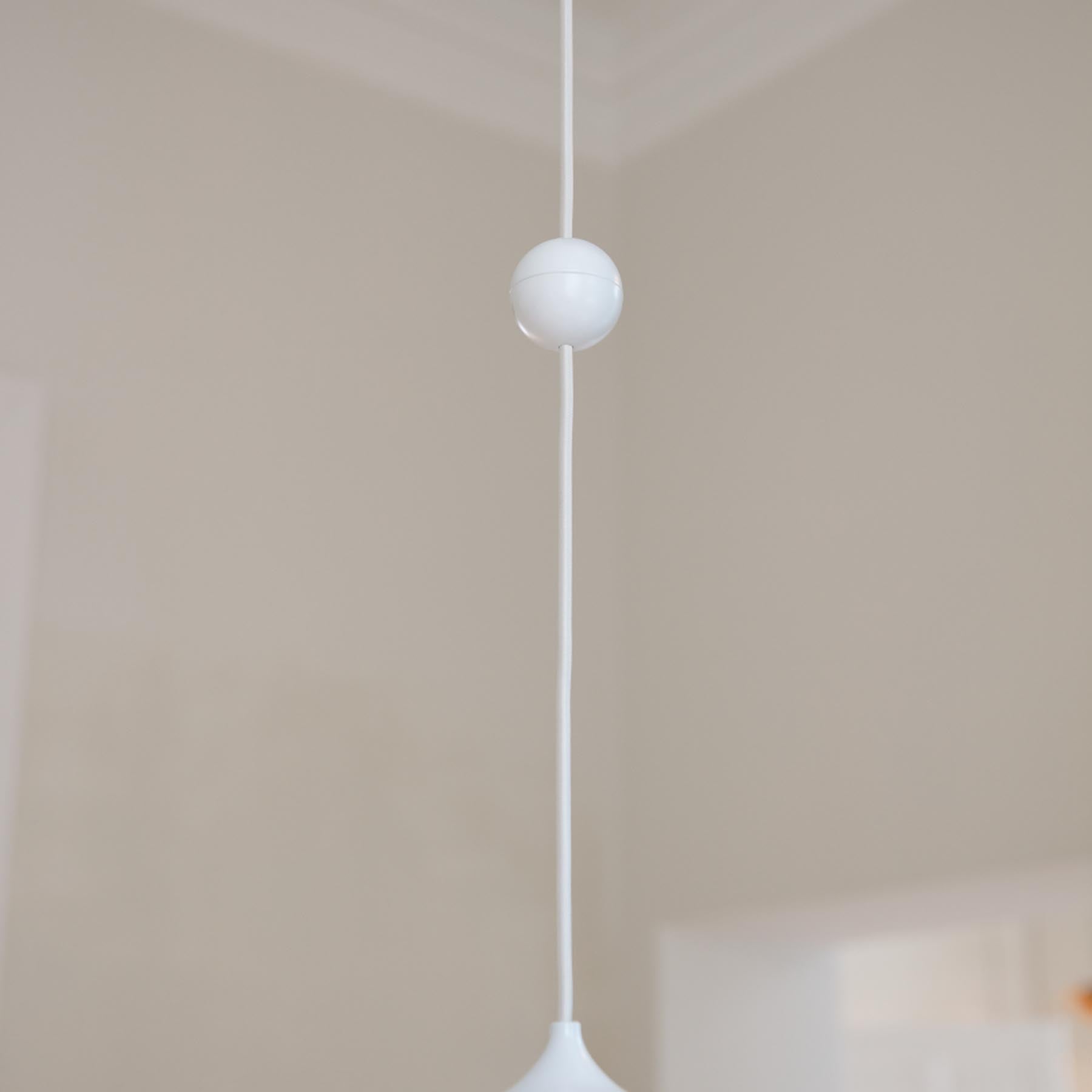 Eleganter Cord Connector in Weiß von Umage, ideal für stilvolle Lampenfassungen und Kabeldesigns, präsentiert in einem modernen Ambiente.