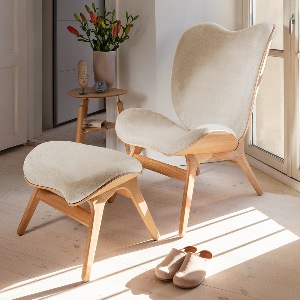 Eleganter Ottoman in sanften Sandtönen, ideal für stilvolle Wohnräume, präsentiert von Umage. Perfekt für Gespräche und Entspannung.