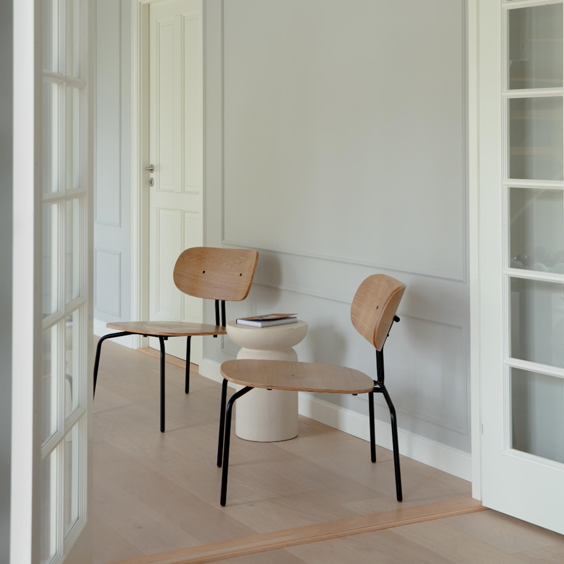 Eleganter Curious Sessel in Teddy White von Umage, stilvoll inszeniert in einem modernen Wohnambiente.