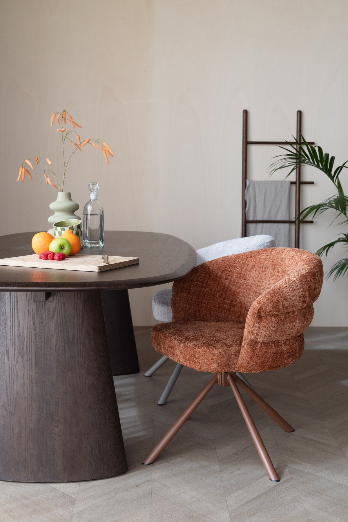 Esstisch Mandy von White Label Living mit ovaler Tischplatte aus Eschenfurnier, schwarzem Gestell und dunklem Walnussfarbton.