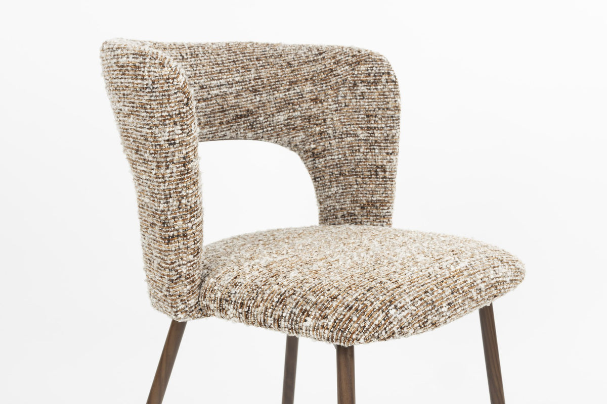 Stuhl Chelsea von White Label Living mit beigem, grob gewebtem Polsterbezug und schlankem Gestell mit bogenförmiger Rückenlehne.