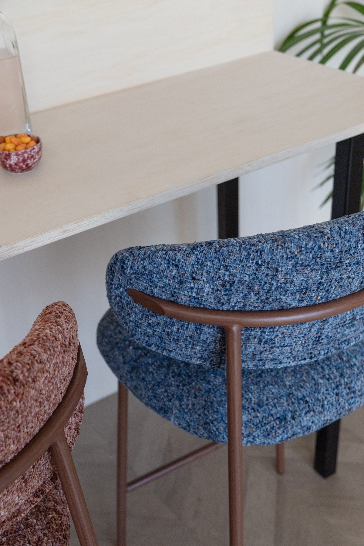 Blauer Barhocker Claes mit meliertem Polyester-Bezug, gepolsterter Sitzfläche und Metallgestell in Walnuss-Holzoptik-Finish.
