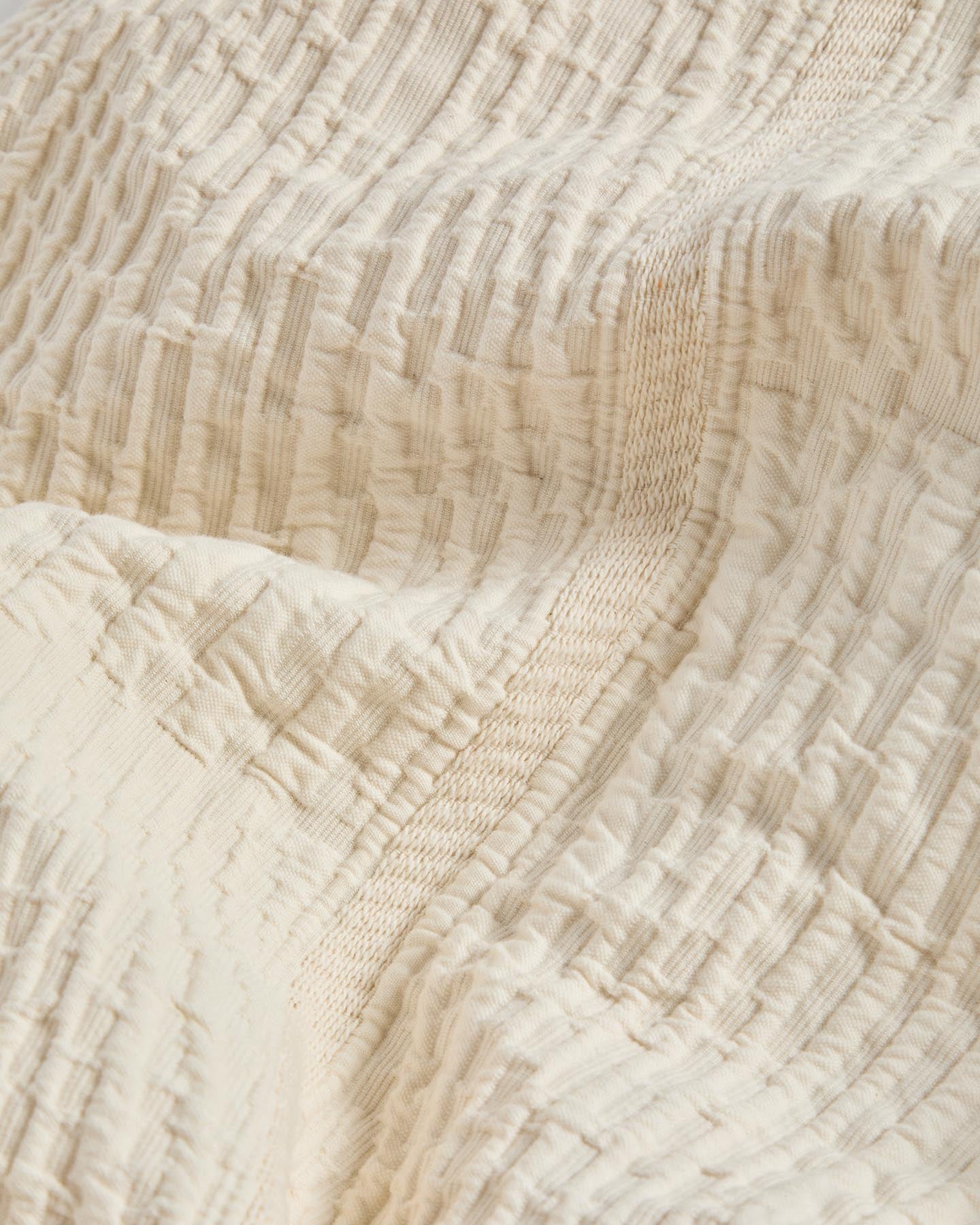Stilvolle Tagesdecke Raylo in sanftem Ecru, gefertigt aus 100 % Baumwolle mit subtiler Streifenstruktur, perfekt für 150/160 cm Betten.