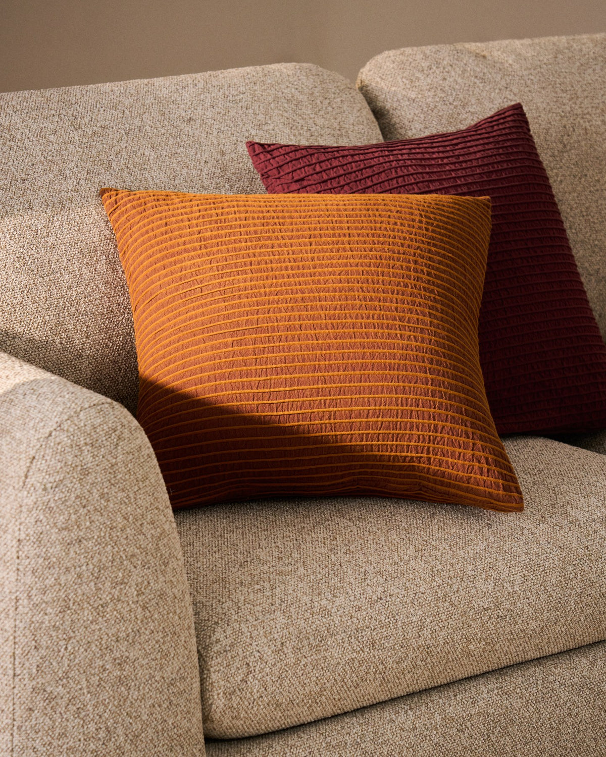 Orangefarbener Kissenbezug Tarilo aus 100 % Baumwolle mit plissierter, gefalteter Struktur, quadratische Form, Grösse 50 x 50 cm.