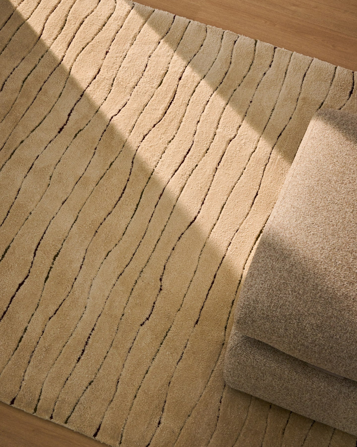 Beiger Teppich Loram aus Polyester mit Fell-Optik und wellenförmigem Reliefmuster, handgefertigt, Grösse 160 x 230 cm.