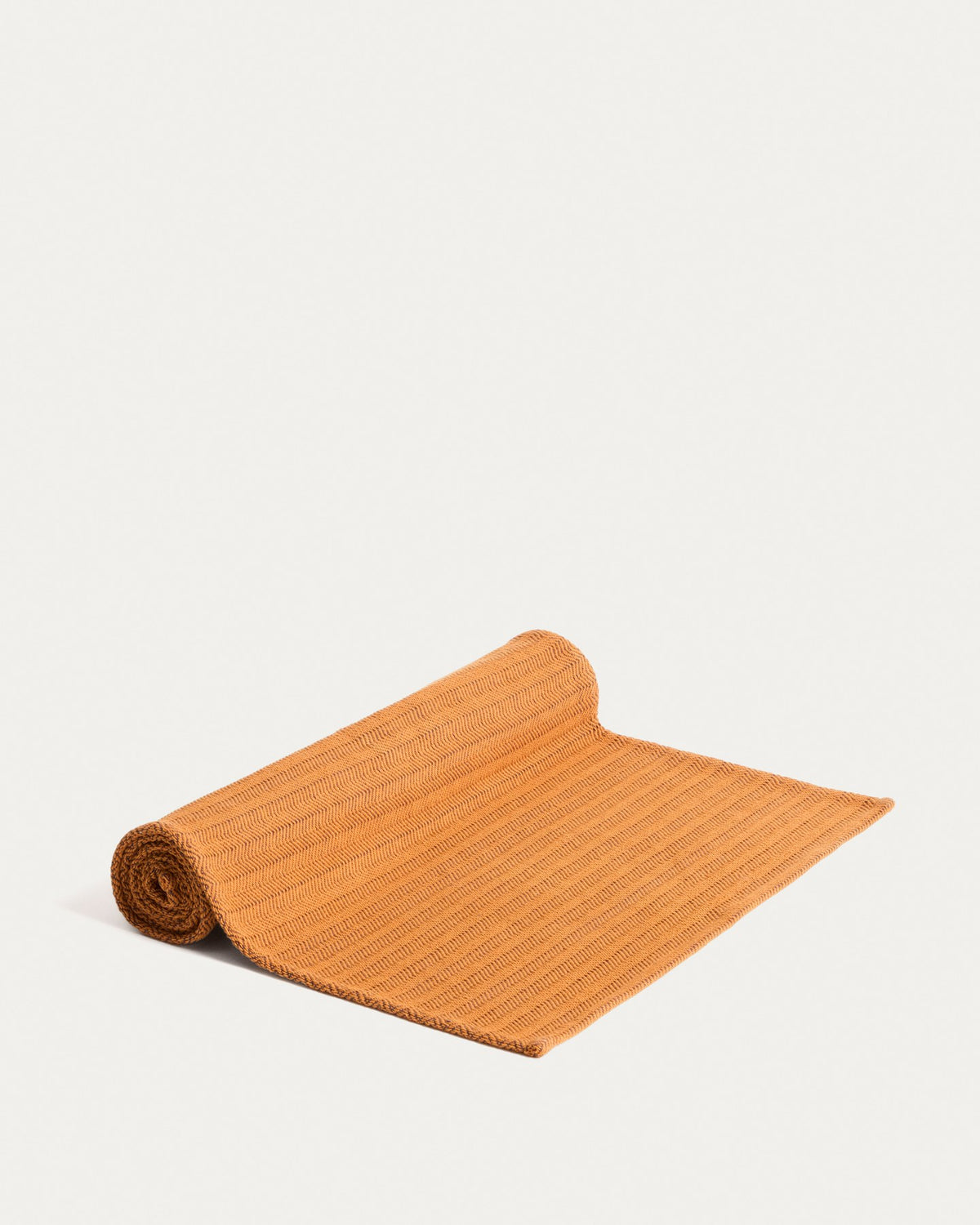 Tischläufer Tieva aus Baumwolle mit eingewebtem Jacquard-Muster in Senfgelb-Orange, rechteckige Form, 50 x 150 cm, auf einem Tisch drapiert.