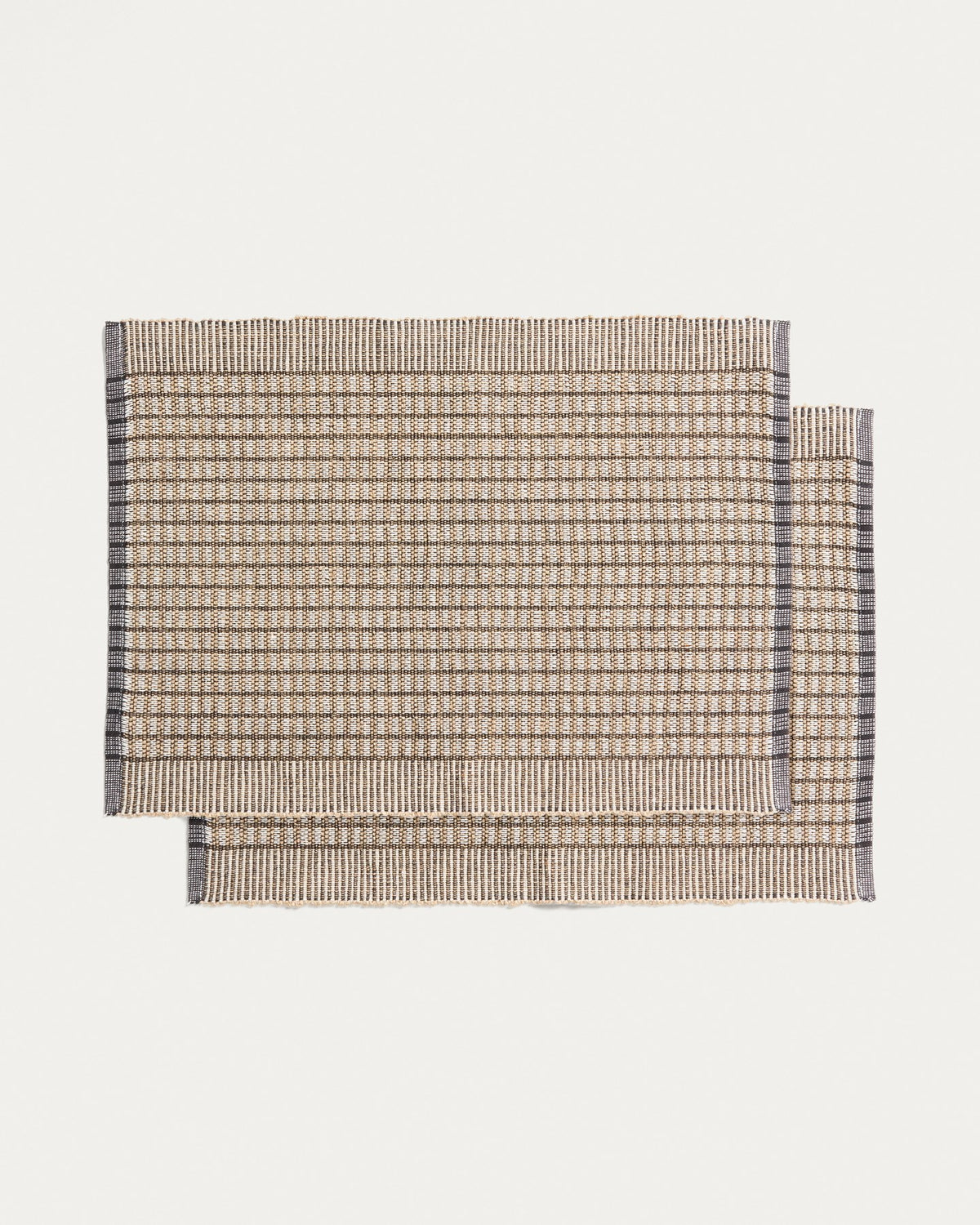 Zwei senfgelbe Tischsets aus Baumwolle und Jute mit strukturierter Webung, rechteckige Form, auf einer Tischplatte platziert.