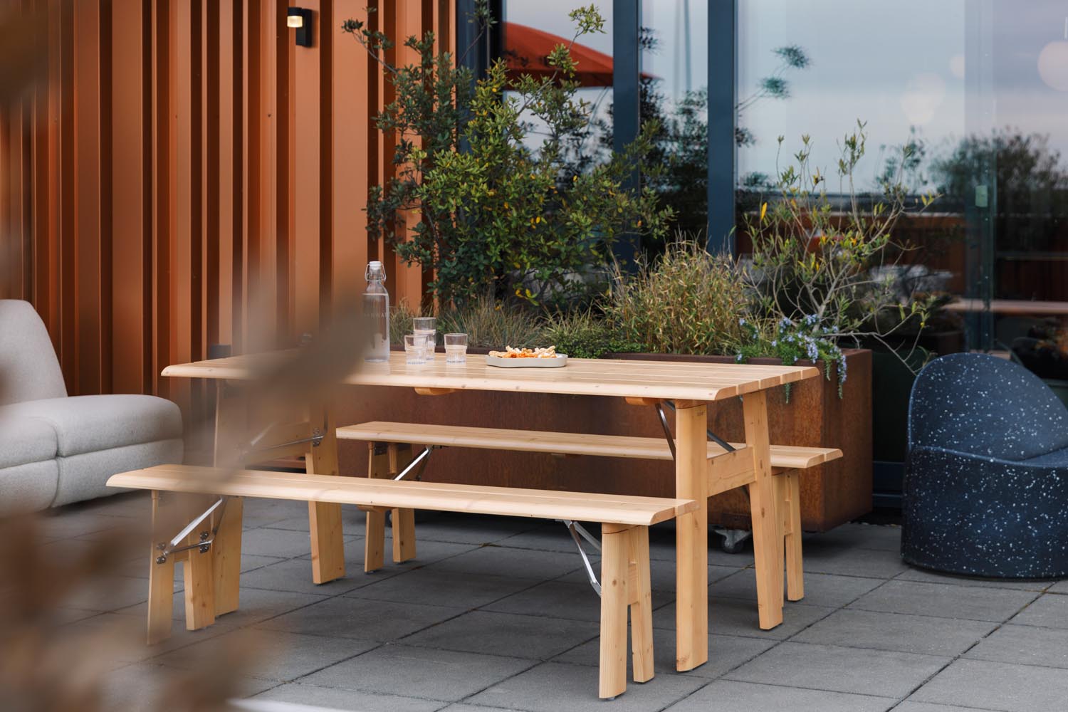 Erleben Sie das elegante Gartentischset Avenue von Zuiver – klappbar, mit integriertem Flaschenöffner und ideal für entspannte Momente im Freien.