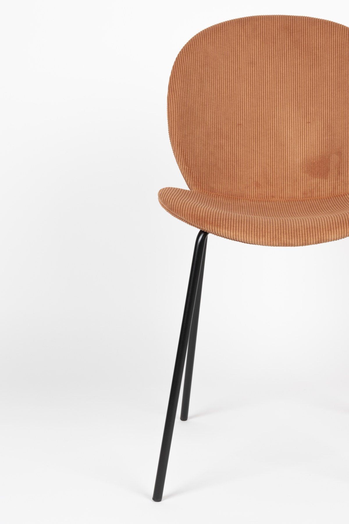 Stuhl Bonnet von Zuiver mit gepolstertem Sitz aus Cordstoff in Oker, schwarzem Metallgestell und schmaler Rückenlehne im Innenbereich.