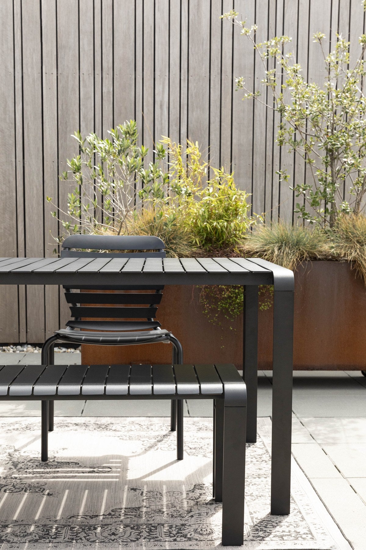 Gartentisch Vondel von Zuiver in Schwarz, rechteckige Tischplatte aus pulverbeschichtetem Aluminium mit schlanken Beinen und Fusskappen aus PP.