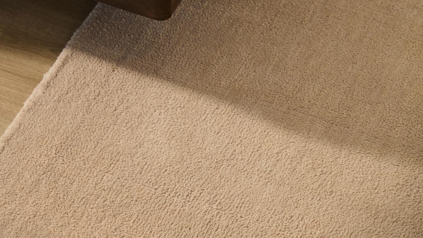 Eleganter beiger Teppich mit feinem Muster, ideal für stilvolle Wohnräume und gemütliche Atmosphären.