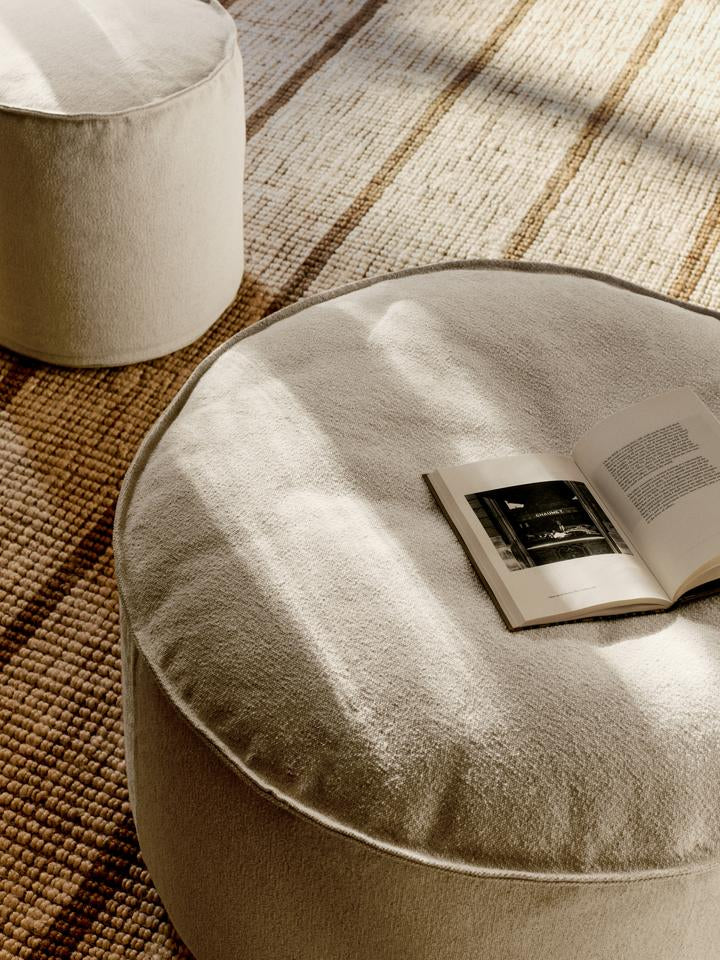 Entdecken Sie den Aun Cotton Pouf Ø40 von Ferm Living – ein stilvolles, nachhaltiges Möbelstück, das Komfort und Eleganz vereint.
