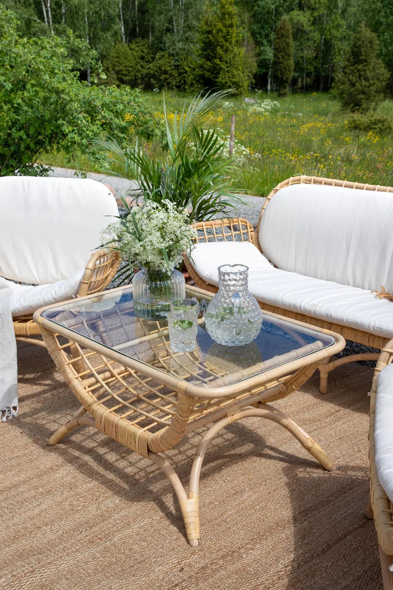 Der Moana Beistelltisch von Venture Home vereint exotisches Design mit robustem Rattan und eleganter Glastischplatte für stilvolle Outdoor-Momente.