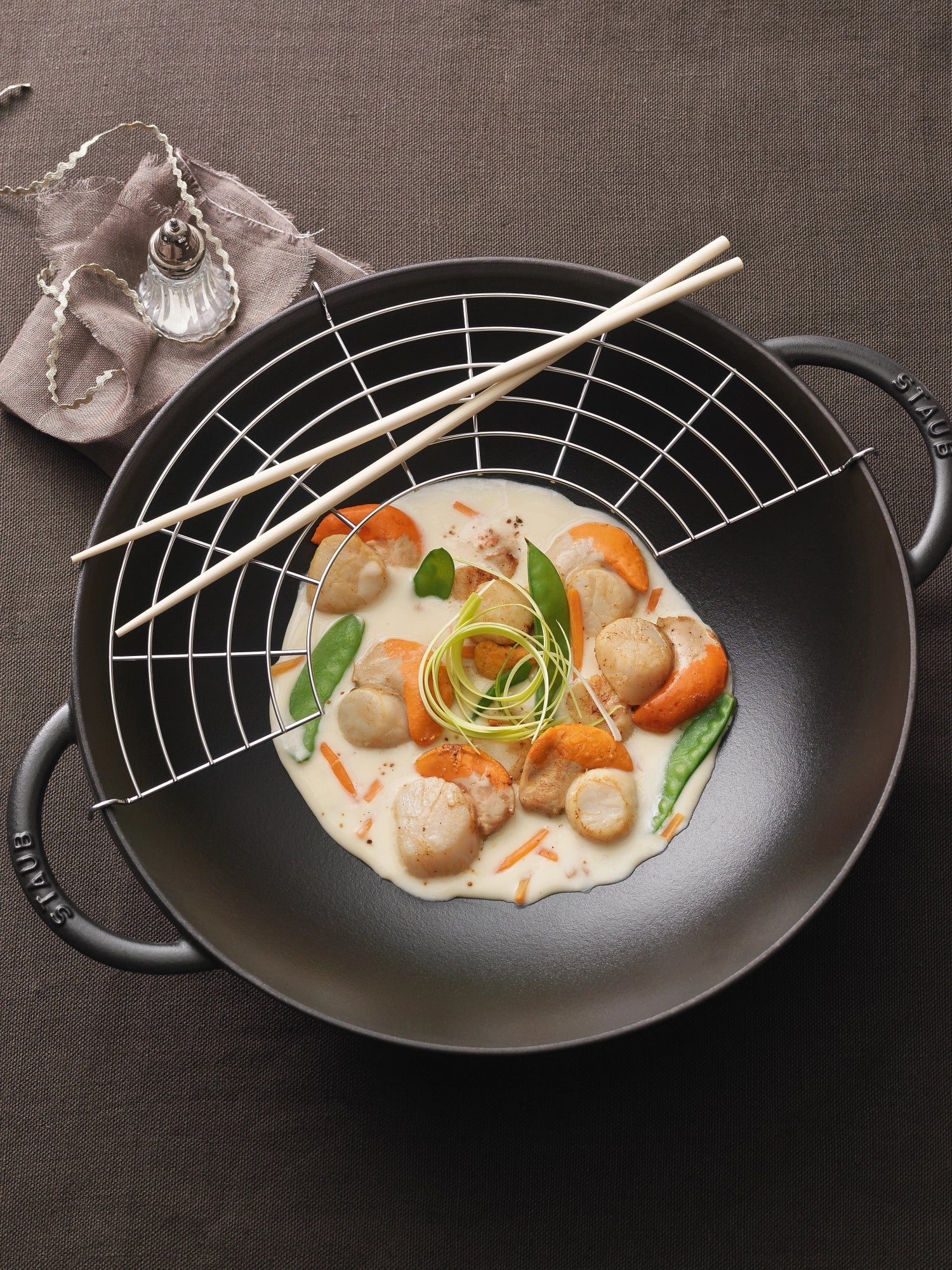 Erleben Sie den Staub Wok mit Glasdeckel 5.7l: Robustes Gusseisen für perfekte Garergebnisse, elegantes Design und viel Platz für köstliche Gerichte.