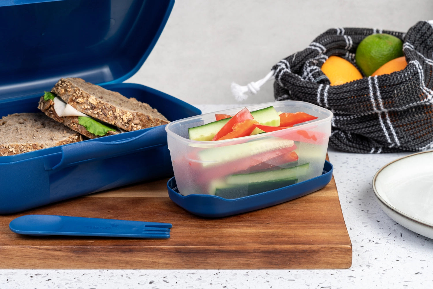 Stilvolle dunkelblaue Lunchbox von Amuse mit integriertem Göffel, perfekt für gesunde Brunch-Salate und Snacks to go, handlich und praktisch.
