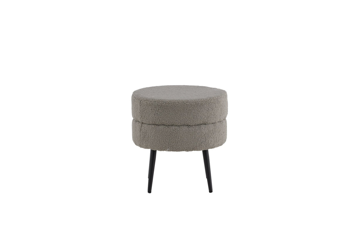 Runder Pouf Pot in Grau mit Teddystoff-Bezug, Durchmesser 40 cm, auf schwarzen, leicht ausgestellten Stahlbeinen stehend.