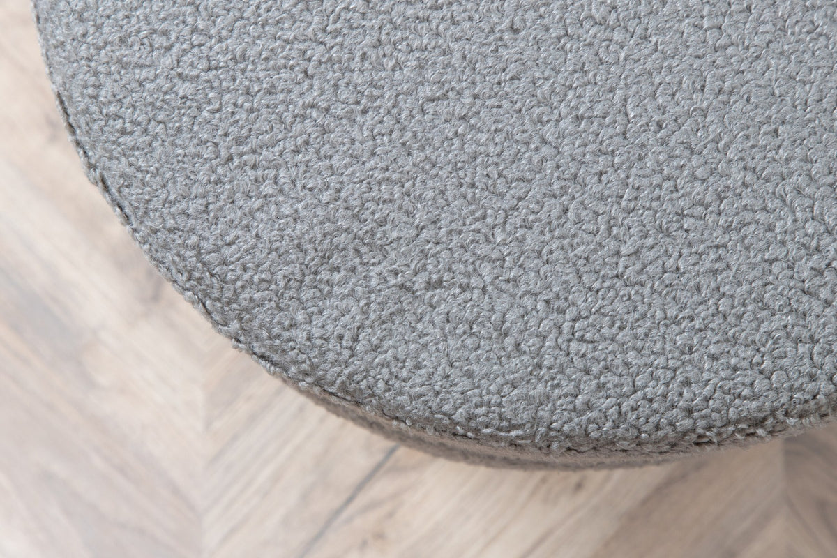 Runder Pouf Pot in Grau mit Teddystoff-Bezug, Durchmesser 40 cm, auf schwarzen, leicht ausgestellten Stahlbeinen stehend.