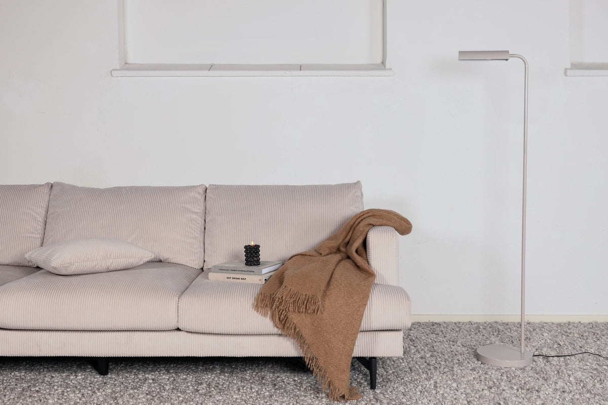 Schlanke Stehleuchte in Beige aus PVC und Stahl, schmaler Lampenschirm auf hohem Standfuss, schlichte moderne Form.