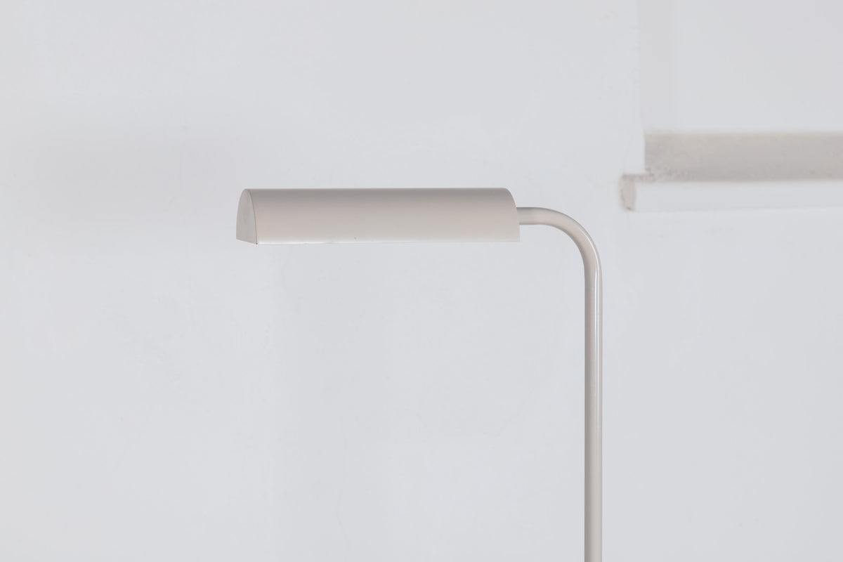 Schlanke Stehleuchte in Beige aus PVC und Stahl, schmaler Lampenschirm auf hohem Standfuss, schlichte moderne Form.