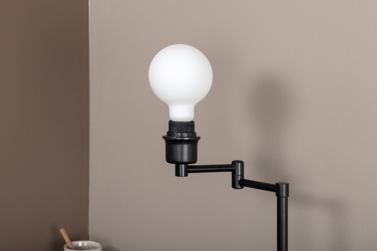 Schwarze Virro Tischleuchte aus PVC und Stahl mit verstellbarem Ständer und offen sichtbarer Glühbirne, freistehend fotografiert.