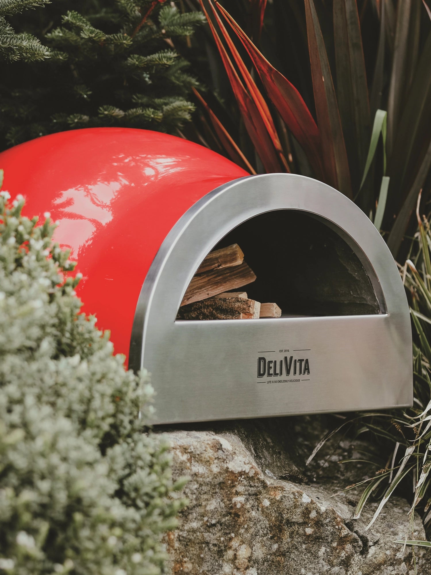 Der Delivita Chillirot Pizzaofen in elegantem Rot, ideal für die Zubereitung köstlicher Pizzen im Freien, vereint Funktionalität und Ästhetik.