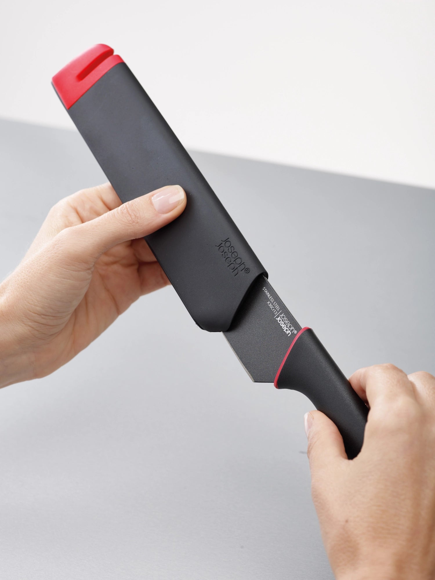 Zwei stilvolle Küchenmesser im Set, rot-grau, ausgestattet mit einem praktischen Schärfer für präzises und einfaches Schneiden in der Küche.