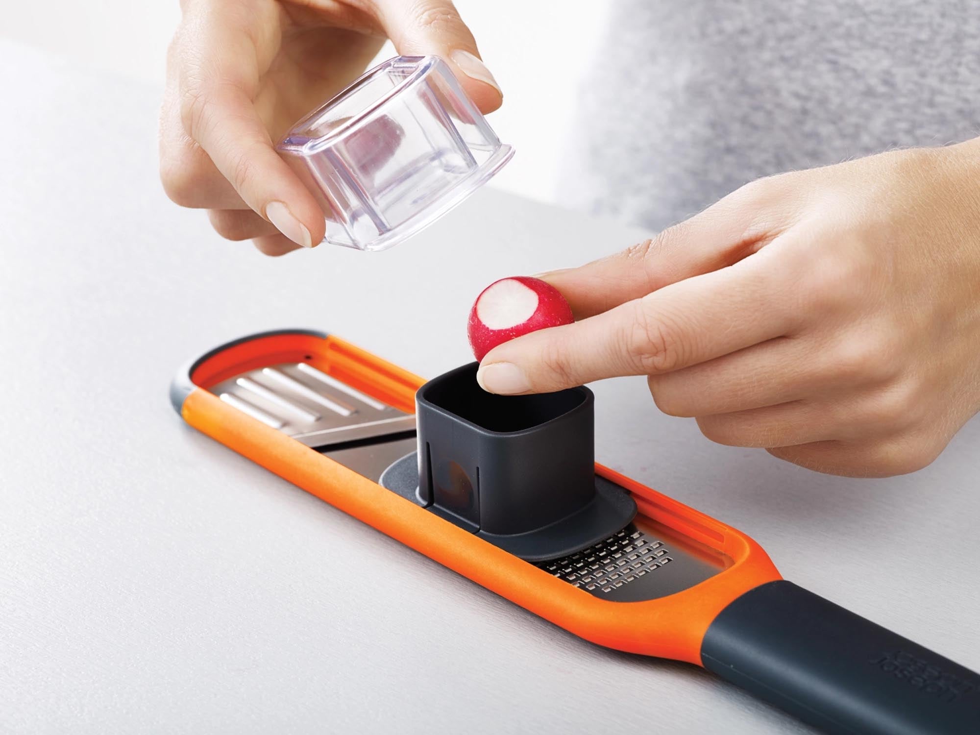 Kompakte Handi-Grate Reibe in Orange für präzises Reiben und Zesten.