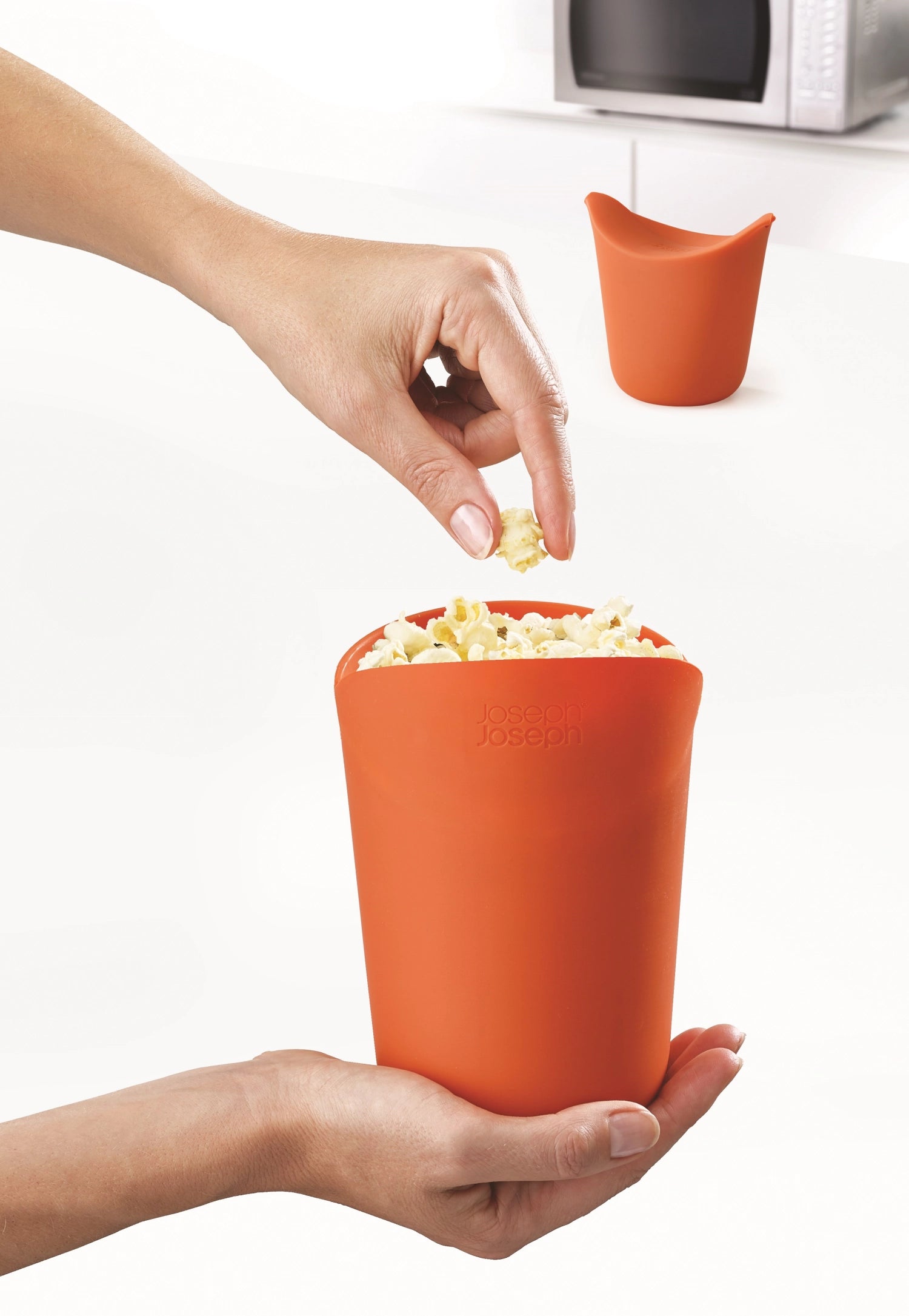 Zwei praktische M-Cuisine Popcorn Maker von Joseph Joseph, klein und handlich (11x14.9x10 cm), für leckeres, selbstgemachtes Popcorn im Handumdrehen.