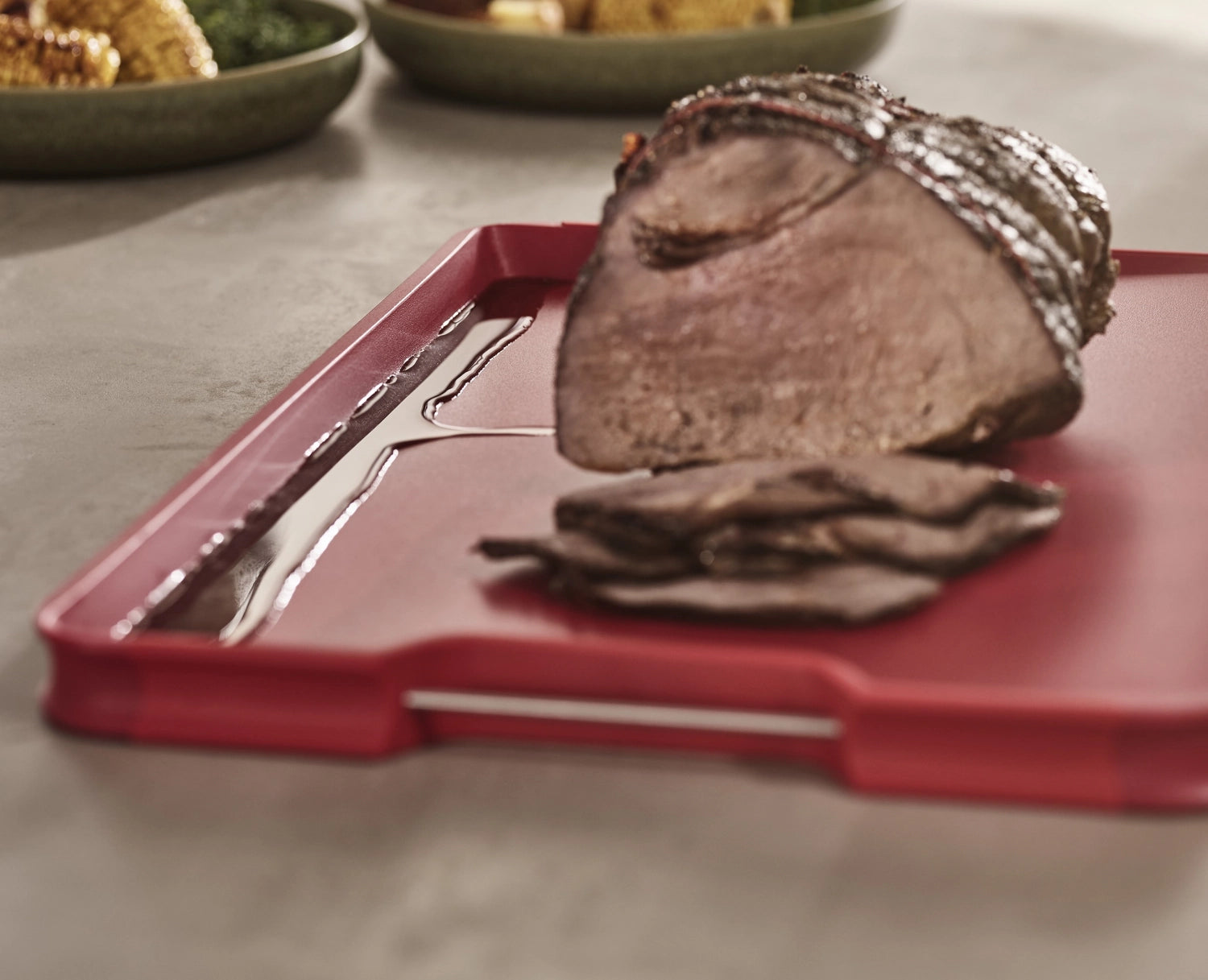 Großes rotes Cut&Carve Plus Schneidebrett von Joseph Joseph, perfekt für das Schneiden und Servieren von Lebensmitteln, mit praktischen Funktionen.