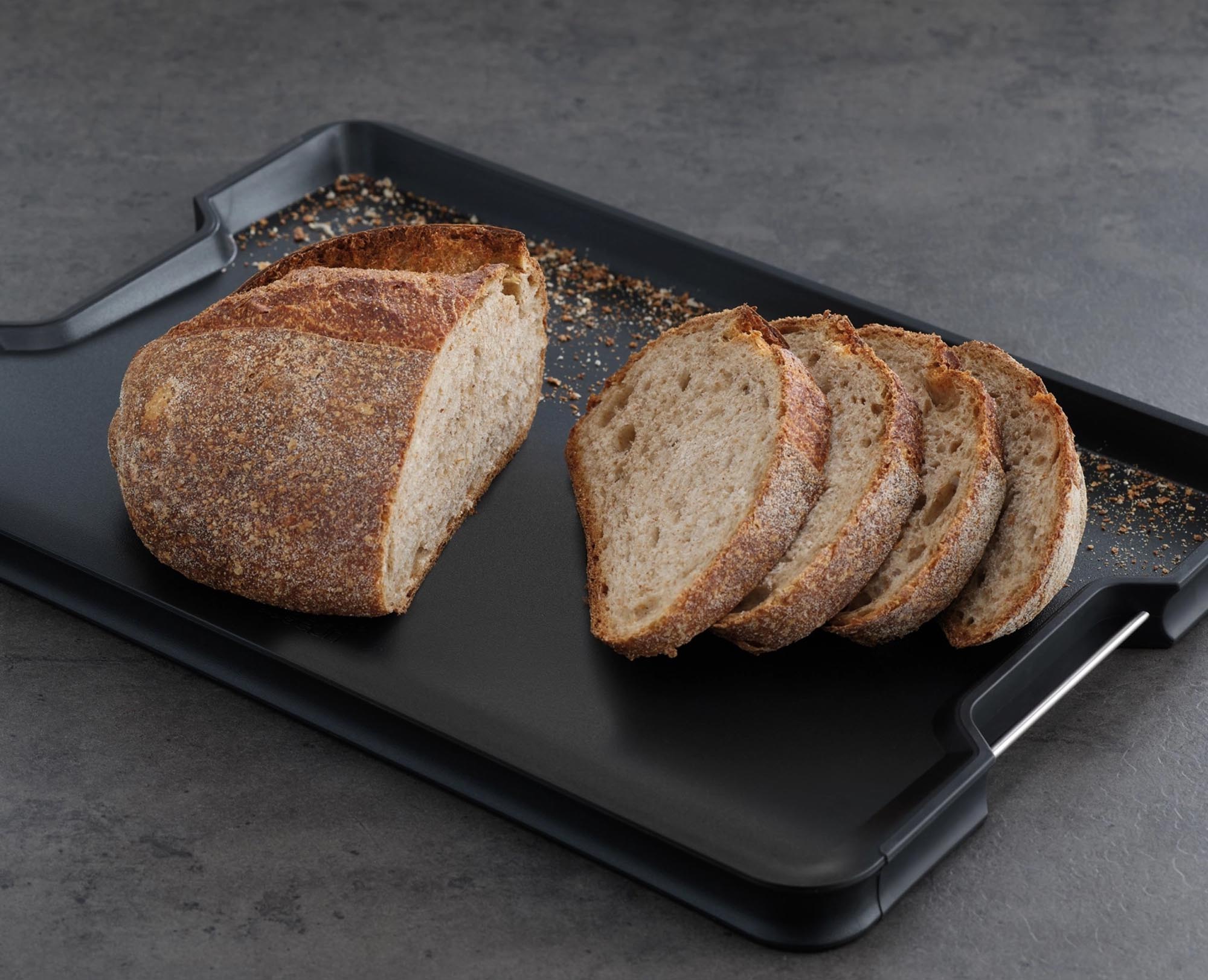 Entdecken Sie das Cut&Carve Plus Schneidebrett in Schwarz von Joseph Joseph: extra groß, hygienisch, spülmaschinenfest und mit praktischen Ablaufrinnen für müheloses Schneiden.