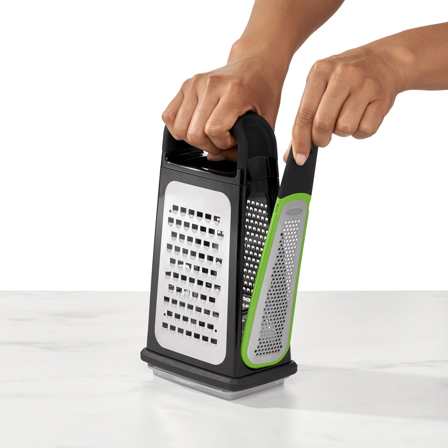 Praktische OXO Kastenreibe mit Zestenreisser, perfekt zum Reiben von Käse, Gemüse und Obst. Ergonomisch gestaltet für müheloses Arbeiten in der Küche.