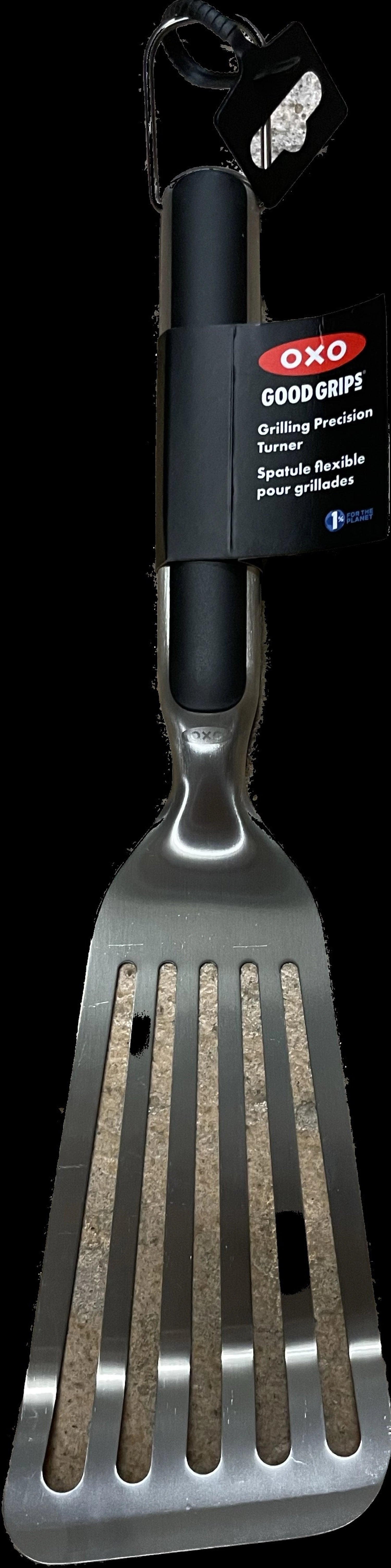 Hochwertiger Grillwender aus Edelstahl von OXO, ausgestattet mit ergonomischem, rutschfestem Griff für müheloses Wenden von Fleisch und Gemüse.