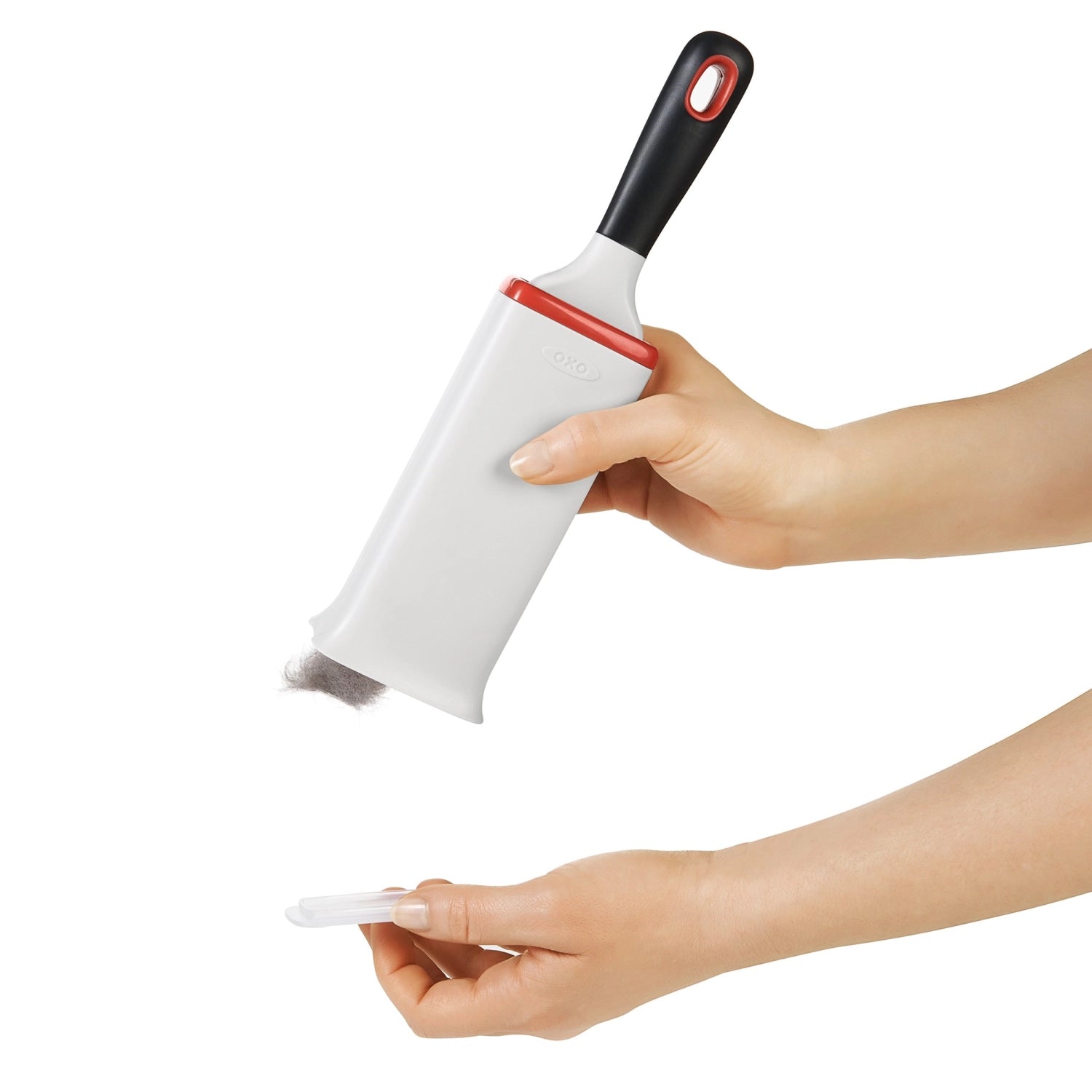 Praktische Flusenentferner-Bürste in elegantem Weiß-Orange von OXO, perfekt für die mühelose Entfernung von Fusseln und Tierhaaren von Kleidung.