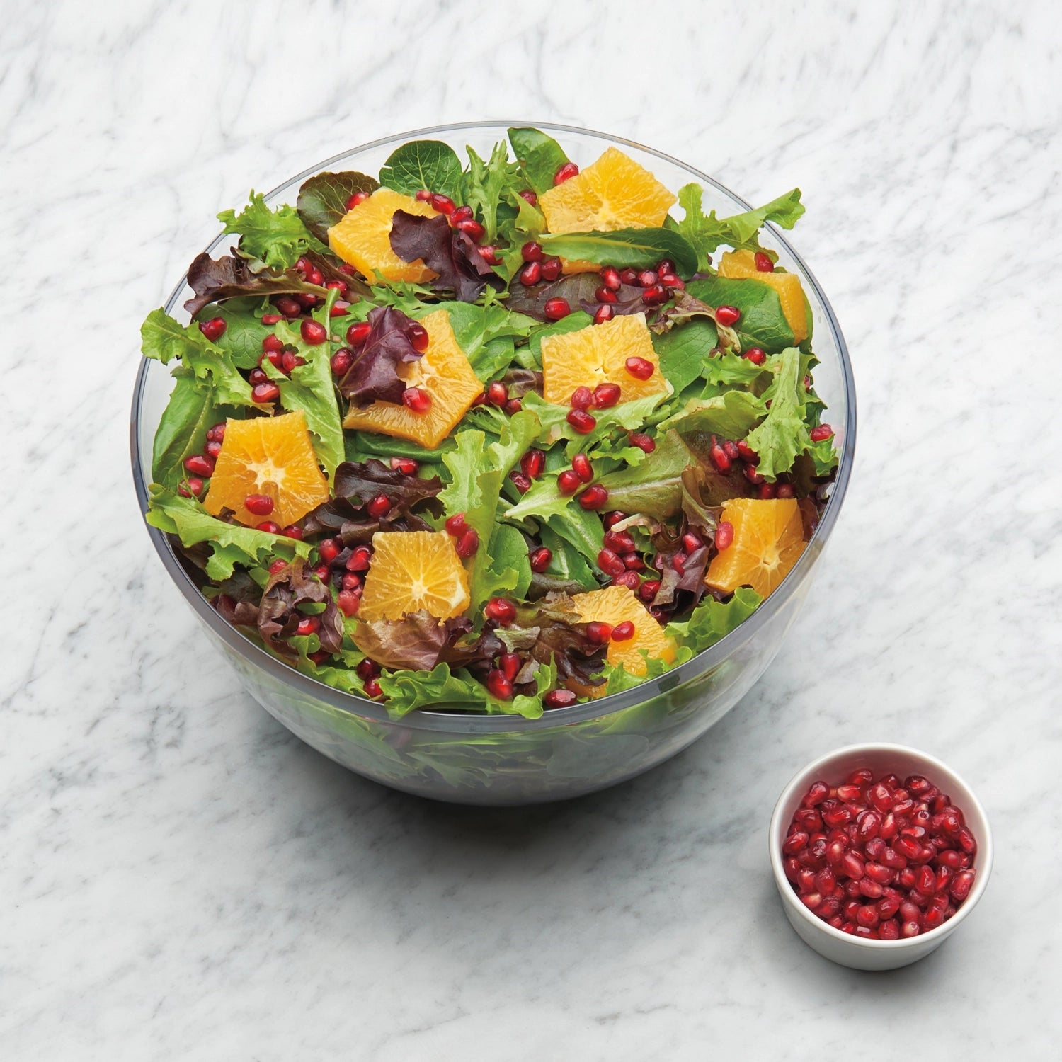 Große, runde Salatschleuder von OXO mit transparentem Design, 5,8 l Fassungsvermögen und 26,7 cm Durchmesser – perfekt für knackige Salate.