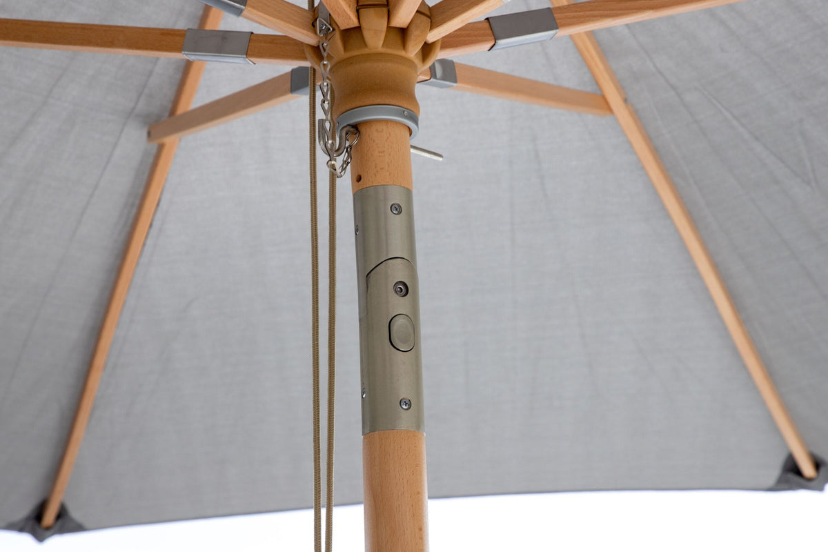 Grauer Sonnenschirm Nypo von Venture Home mit Polyester-Bezug und Ständer aus Buchenholz, aufgespannt im Aussenbereich.