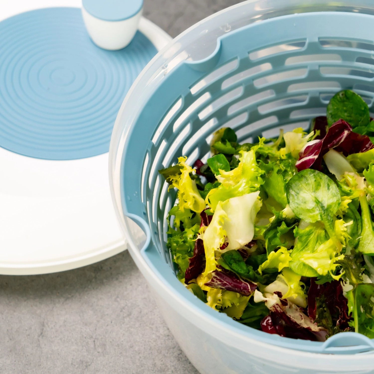 Moderne Spinderella Salatschleuder in ansprechendem Blau, rutschfeste Unterlage für sicheren Stand, 4.4l Volumen für frische Salate.